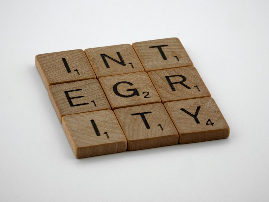 a scrabbled wooden block with the words integr city on it